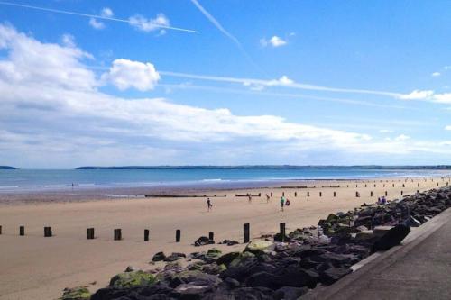 a group of people on a beach with the ocean at Villa in Youghal - Carleton Village in Youghal