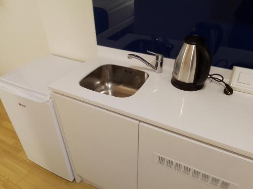 a kitchen with a sink and a kettle on a counter at ORBI CITY in Batumi