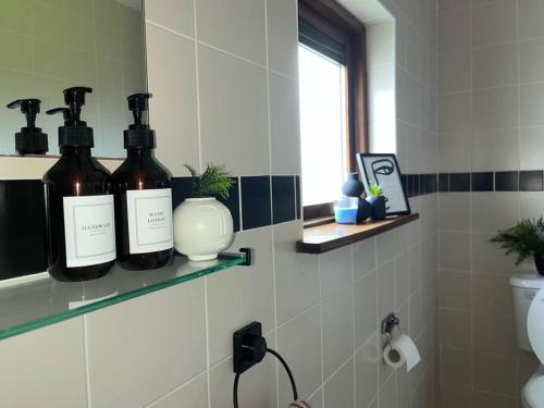 two bottles of wine on a shelf in a bathroom at Villa in Youghal - Carleton Village in Youghal