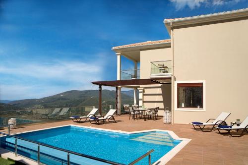 a villa with a swimming pool and a patio at Heavenly Heights Villas By KB Hospitality in Évyiros