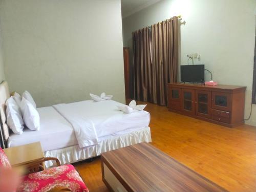 Tempat tidur dalam kamar di Hotel Ompu Herti