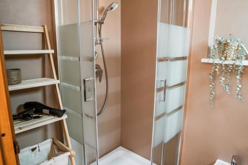 La salle de bains est pourvue d'une douche avec une porte en verre. dans l'établissement Belvedere - Terrazza panoramica, à Bosa