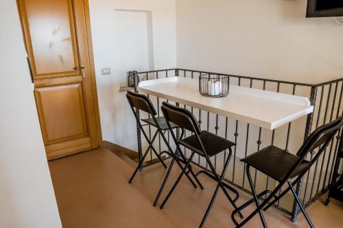 a small kitchen with a table and four chairs at Belvedere - Terrazza panoramica in Bosa
