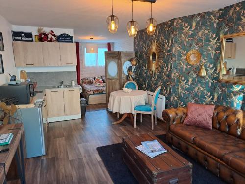 un salon avec un canapé et une table dans l'établissement gîte la bohème, à Saint-Valery-sur-Somme