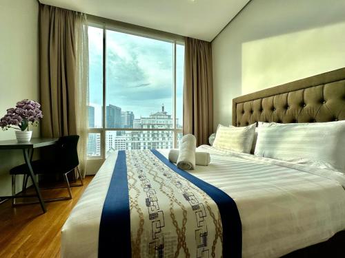 a hotel room with a large bed with a window at Soho Klcc Suites by Liala in Kuala Lumpur