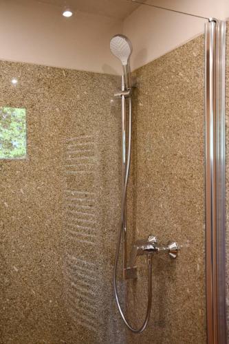 La salle de bains est pourvue d'une douche avec un pommeau de douche. dans l'établissement Villa Larix-Das Vollholzhaus direkt am Berzdorfer See, à Görlitz