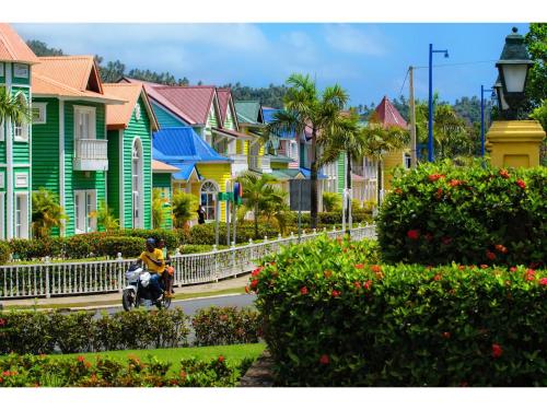 a man riding a motor scooter down a street at Room in Guest room - Best bed and breakfast in Samana Breakfast Included in Santa Bárbara de Samaná