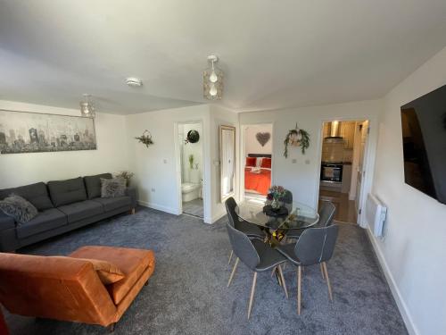 a living room with a couch and a table and chairs at Luxury One Bed Apartment Stevenage in Stevenage