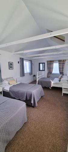 1 dormitorio con 2 camas y 2 sofás en Hunters Meet, en Bishops Stortford