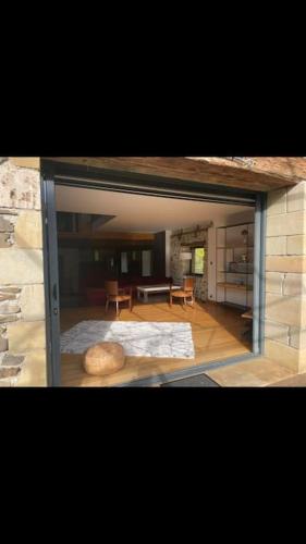 une porte en verre du salon avec une table dans l'établissement La Grange du Colombier - Saint Geniez d'Olt et d'Aubrac, à Saint-Geniez-dʼOlt