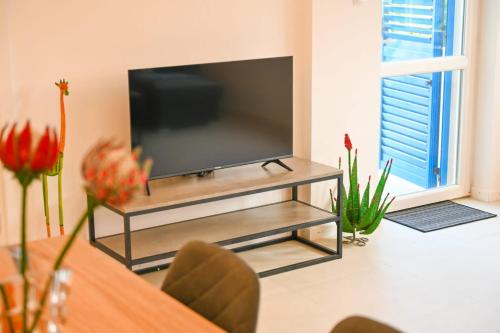einen Flachbild-TV auf einem Stand in einem Wohnzimmer in der Unterkunft Apartment Leo Blue in Vela Luka