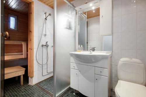 a bathroom with a sink and a toilet and a shower at Apartments Karviaismäki in Helsinki