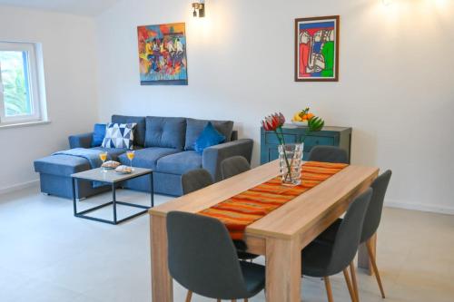 sala de estar con mesa y sofá azul en Apartment Leo Blue en Vela Luka