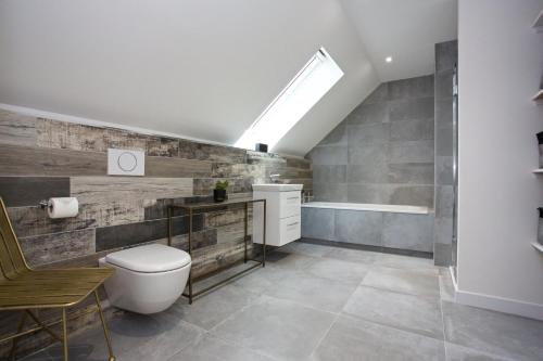 a bathroom with a toilet and a bath tub at LOCH TAY HIGHLAND LODGES and GLAMPING PARK in Morenish
