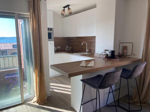 une cuisine avec un comptoir et deux tabourets de bar dans l'établissement Villa Botrel 3* Superbe appartement vue mer, à Sainte-Maxime