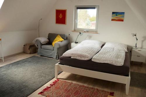 a bedroom with a bed and a couch and a window at Haus Seenplatte in Groß Nemerow