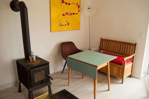 a room with a stove and a table and a chair at Haus Seenplatte in Groß Nemerow