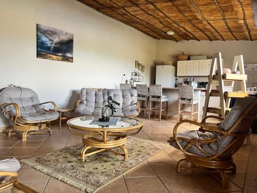 a living room with a table and chairs and a kitchen at Uitzicht Private Nature Reserve and Lodge in Fouriesburg