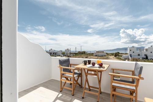 stół i krzesła na balkonie z widokiem w obiekcie Sunshine Plaka Naxos w mieście Plaka