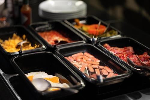 a group of three trays of food with eggs and meats at Bohem Art Hotel in Budapest