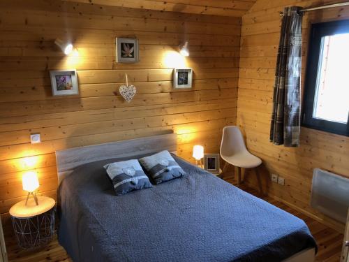 a bedroom with a blue bed in a wooden wall at Chalet Jad'Orres in Les Orres
