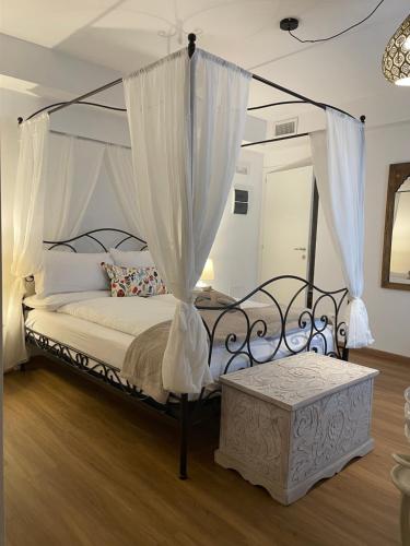 a bedroom with a canopy bed with white curtains at Ai Tre Garofani B&B in Trento