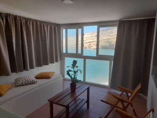 sala de estar con sofá y ventana grande en Beach View Matala, en Matala