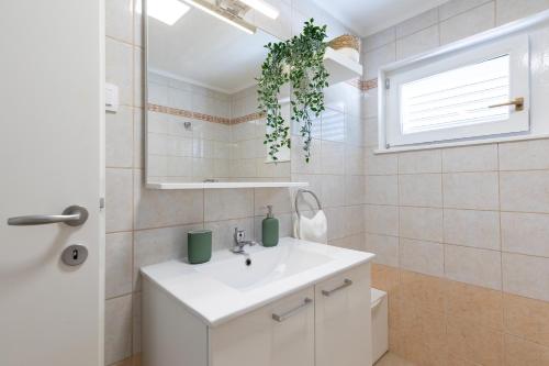 a bathroom with a white sink and a mirror at House Potirna in Blato