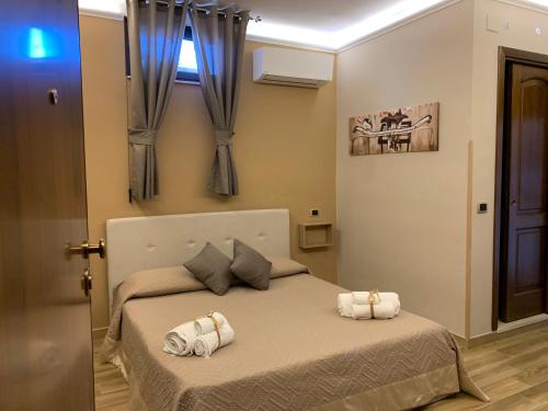 a bedroom with a bed with two towels on it at Emyteo Apartment in Tropea