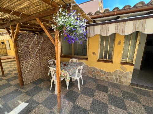 ヴィッラシミーウスにあるAppartamento Nassia 1 By La Via Del Mare Viaggi e Vacanzeのパティオ(パーゴラの下のテーブルと椅子付)