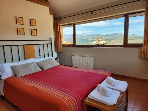 a bedroom with a large bed with a view of the mountains at El Torreón I in Hoyos del Espino