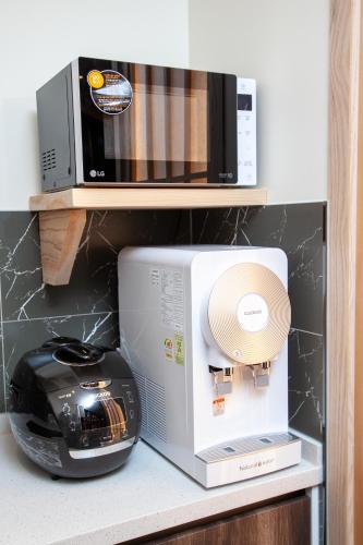a microwave and a toaster oven on a shelf at Gwanganli The Club Hotel in Busan