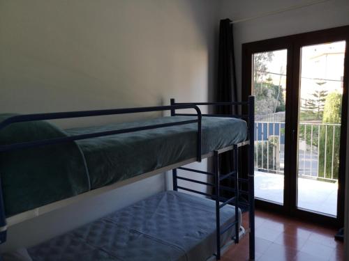 2 Etagenbetten in einem Zimmer mit Balkon in der Unterkunft Can Pau in Begur