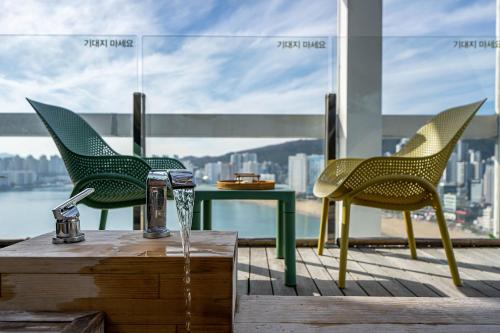 two chairs and a table on a balcony at Gwanganli The Club Hotel in Busan