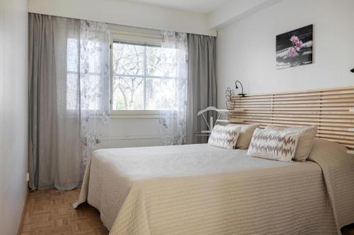- une chambre avec un grand lit et une fenêtre dans l'établissement Apartments Karviaismäki, à Helsinki