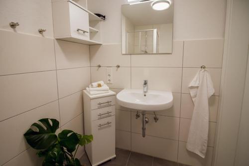 a white bathroom with a sink and a mirror at Oma Husen in Krummhörn