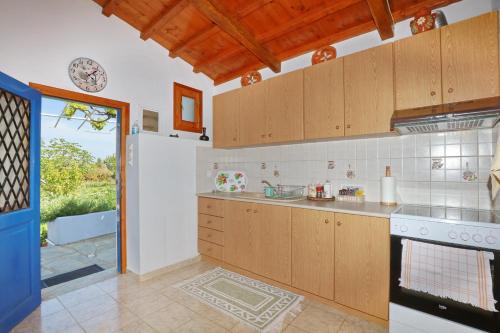 a kitchen with wooden cabinets and a stove at Villa Pefkias in Skopelos Town