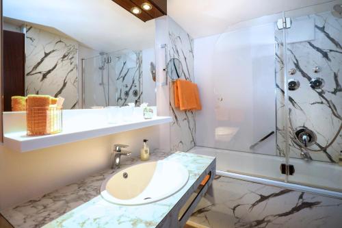 ein Bad mit einem Waschbecken und einer Dusche in der Unterkunft City-Hotel Aschaffenburg in Aschaffenburg