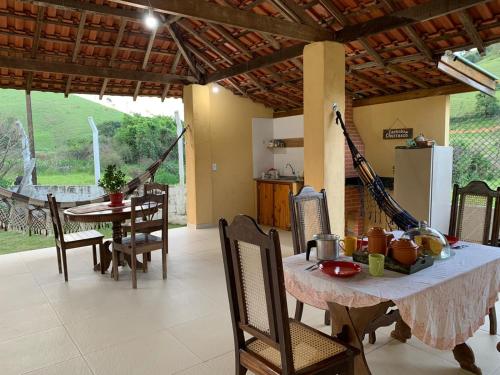 een keuken en eetkamer met een tafel en stoelen bij Sitio Sao Francisco de Assis in Santo Antônio do Pinhal