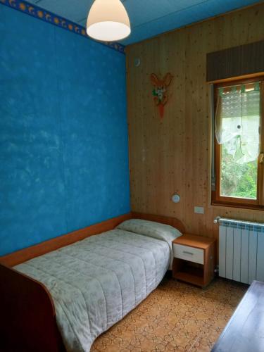 カッローダノ・インフェリオーレにあるCasa Dirindoの青い壁のベッドルーム1室(ベッド1台付)
