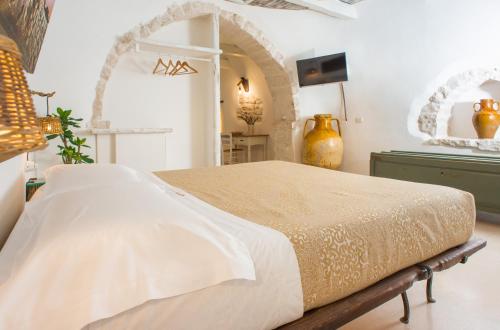 a bedroom with a large bed and a mirror at Trulli Holiday Deluxe & Wellness in Alberobello