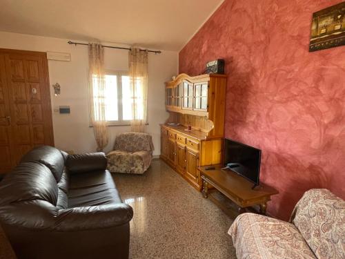 a living room with a leather couch and a tv at Dimora Pina sul mare in Codaruina