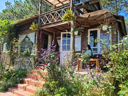 a couple sitting on the porch of a house with flowers at Romantic house on a pine hill Dalat in Xuan An