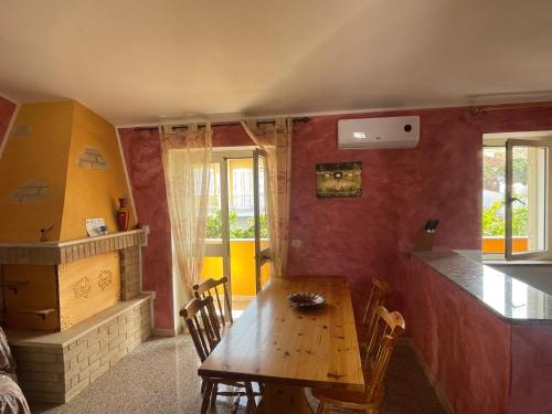 ein Esszimmer mit einem Holztisch und einer Küche in der Unterkunft Dimora Pina sul mare in Codaruina