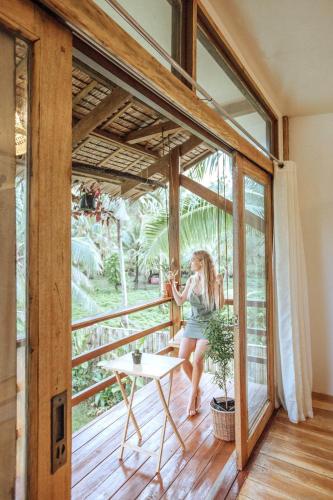 a woman sitting on a chair on the balcony of a house at Mango Tango Villas Siargao in General Luna