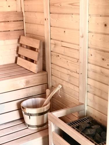 - un sauna en bois avec un seau et une boîte dans l'établissement Appartement Le Verdoyant hyper centre avec Sauna et Parking, à Colmar