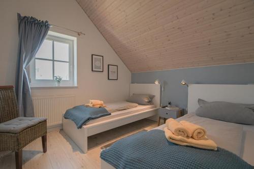 a bedroom with two beds and a window at Ferienhaus Hafenresidenz in Greetsiel