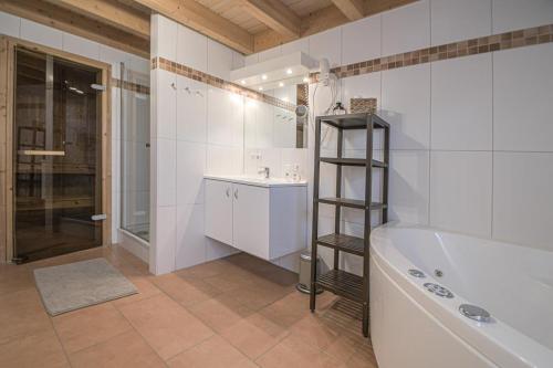 a bathroom with a tub and a sink and a shower at Ferienhaus Hafenresidenz in Greetsiel