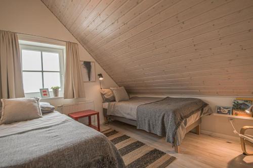 een slaapkamer met twee bedden en een houten plafond bij Hafenparadies in Greetsiel