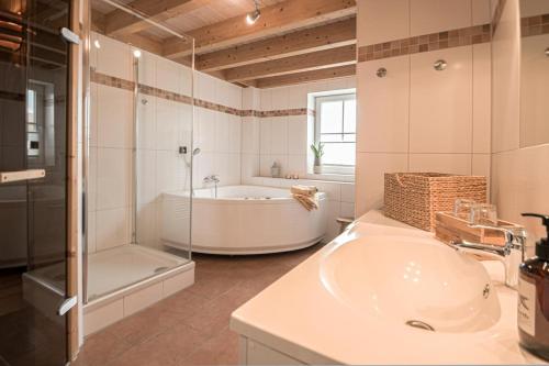 een witte badkamer met een bad en een wastafel bij Hafenparadies in Greetsiel